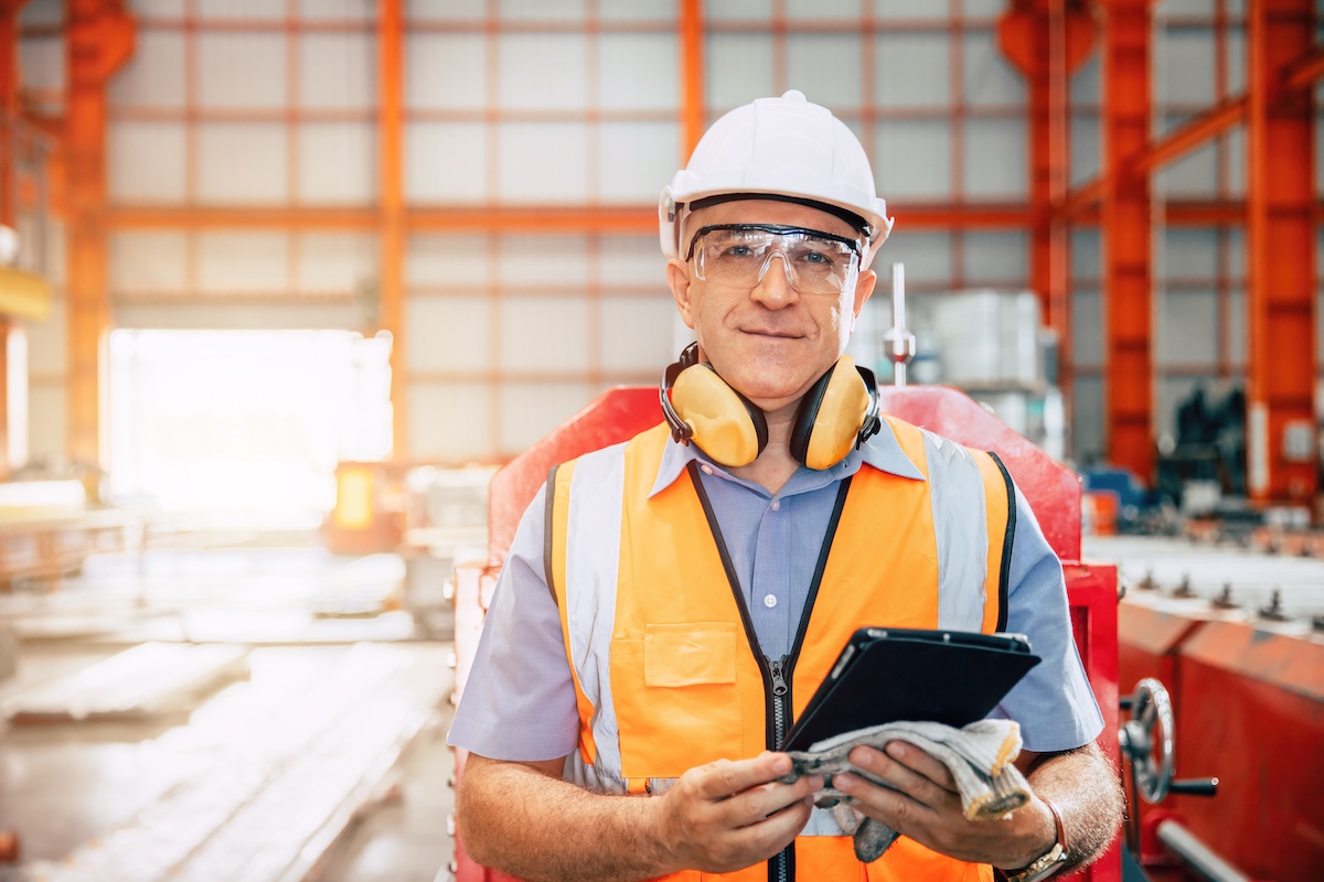 Man working in hardhat with tablet