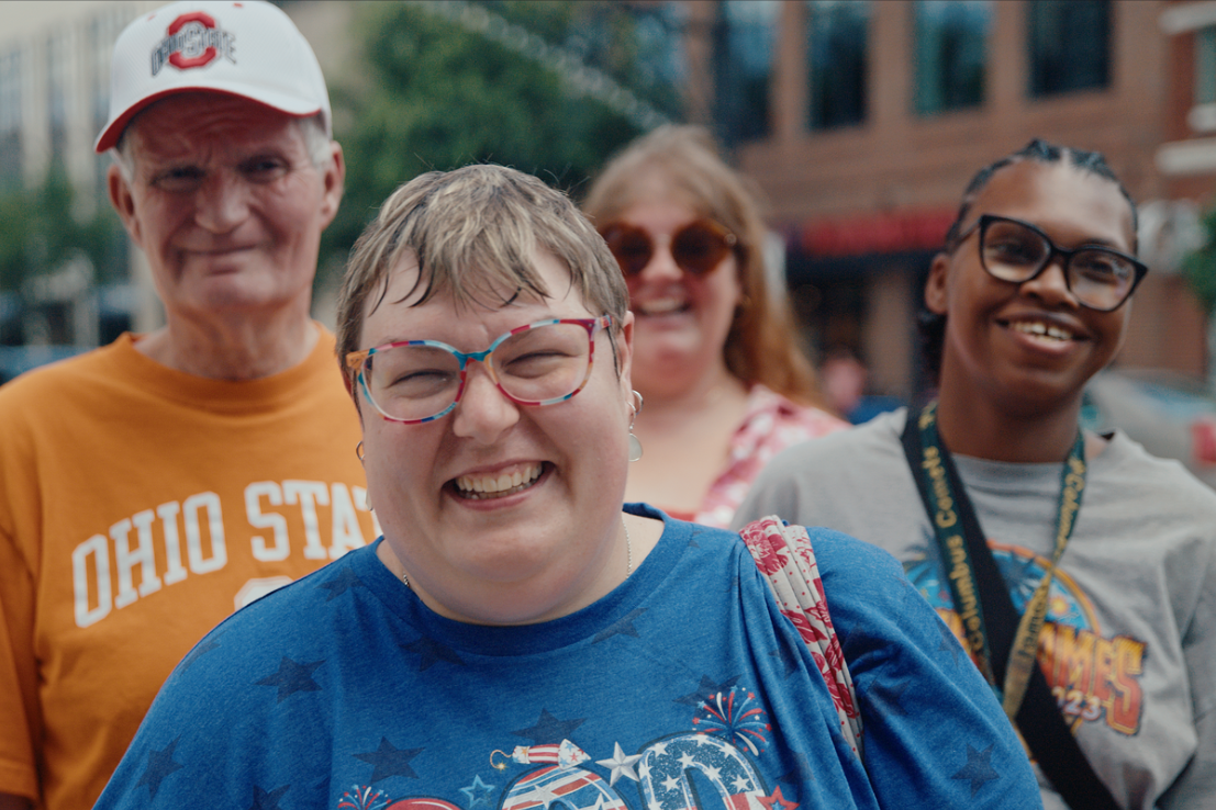 Woman smiling with people standing behind her